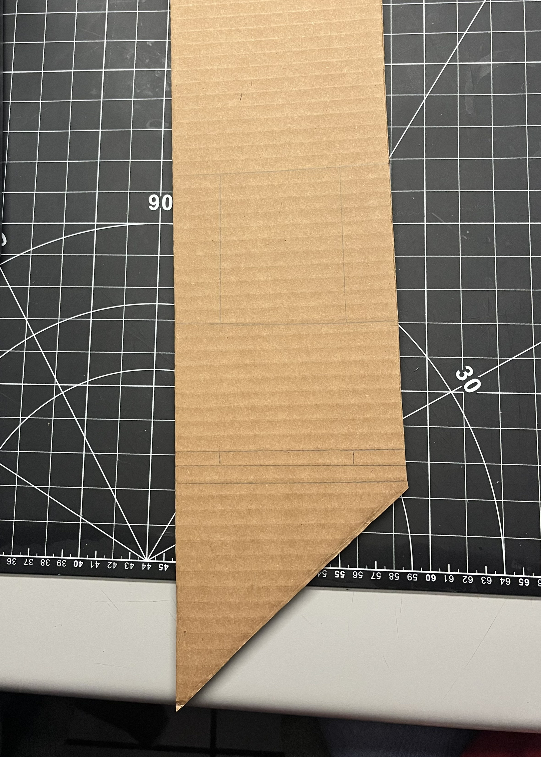 First, we created a design and copied it out onto the cardboard using a pencil and we put numbers and other symbols to display what is what and what should be cut and what shouldn't.