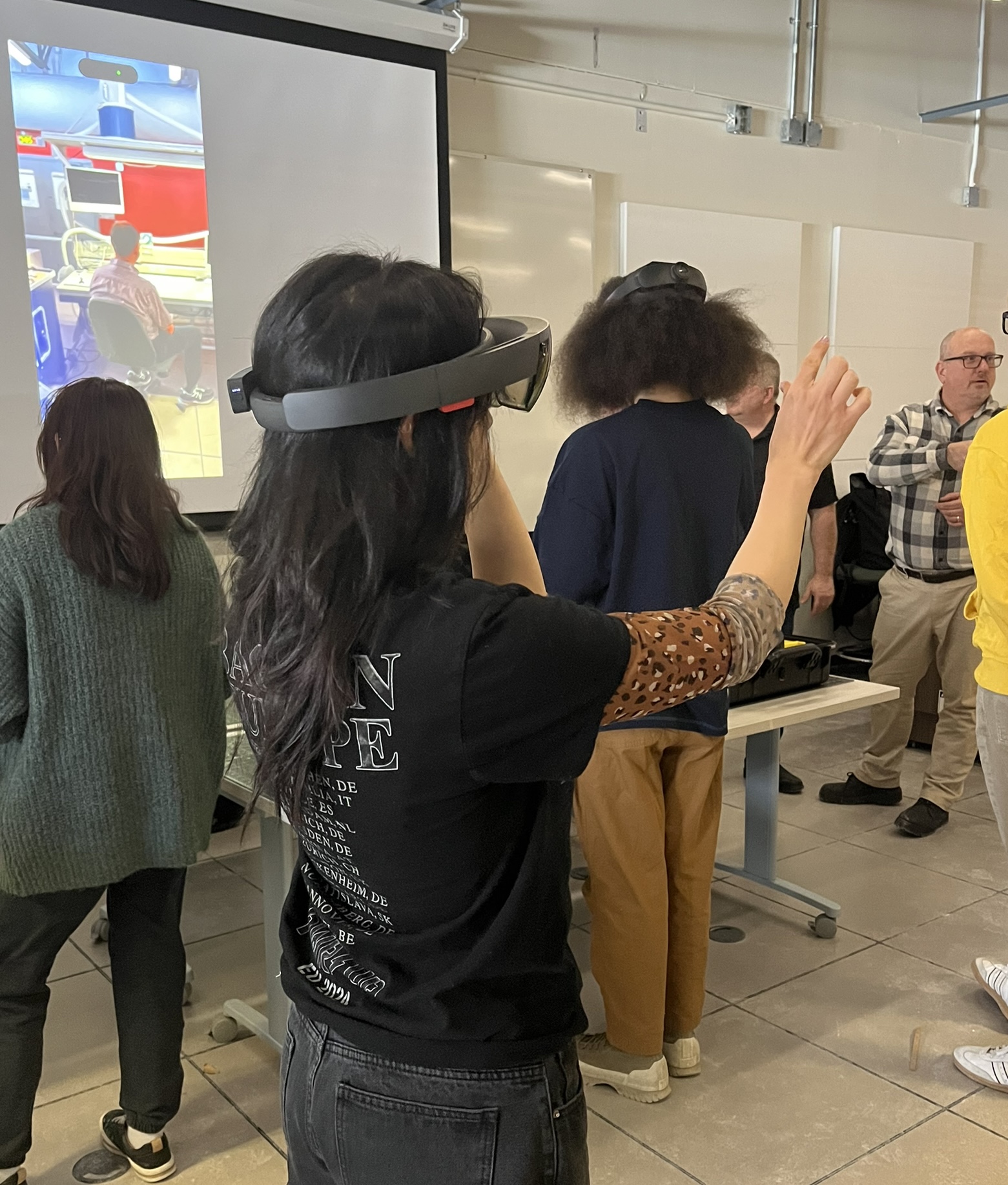 Here Alejandra was playing with the AR headset, which we found out has a little bit more limitations. You're still able to see your surrounding, but also see the content in front of you. Meanwhile, VR, you're fully immersed into the environment.